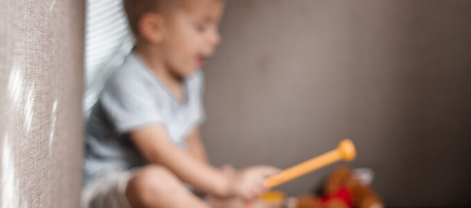 little boy playing toy music instruments
